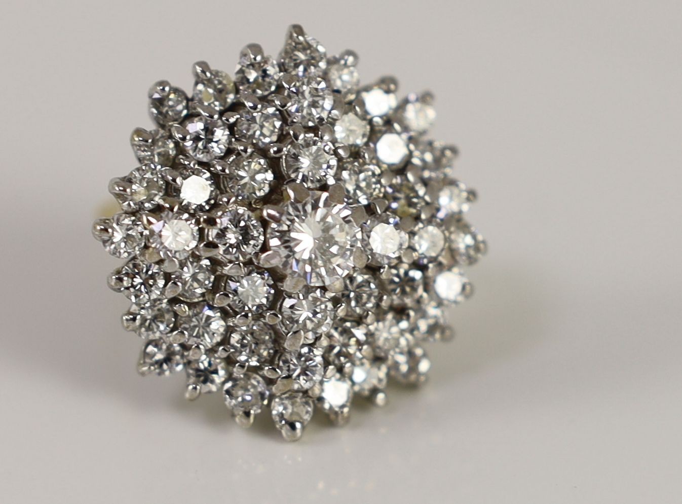 An impressive gold, platinum and diamond set circular cluster ring
